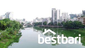 Lakefront view of modern residential buildings in Dhaka, reflecting on the water, suitable for Flat for Rent in Dhaka listings.