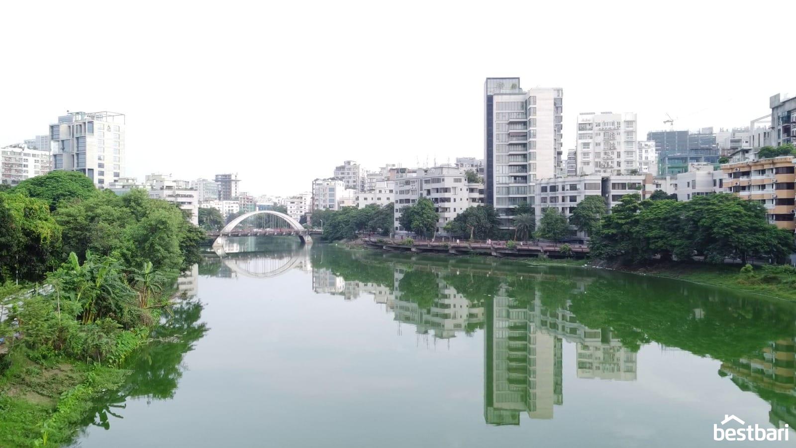 Lakefront view of modern residential buildings in Dhaka, reflecting on the water, suitable for Flat for Rent in Dhaka listings.