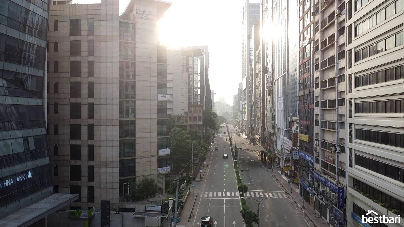 Empty early-morning city street in Bangladesh surrounded by tall commercial buildings, suitable for illustrating a List of Real Estate Company in Bangladesh.